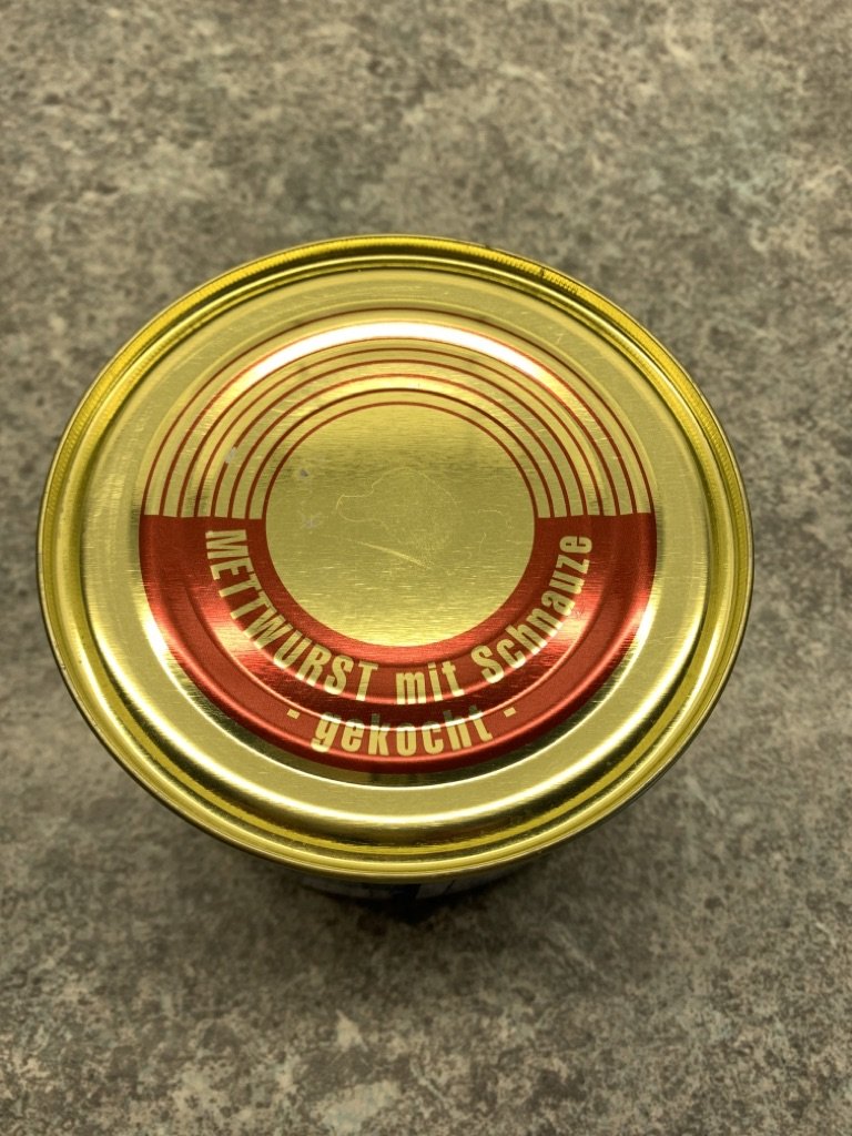Gekochte Mettwurst mit Schnauze in der Dose